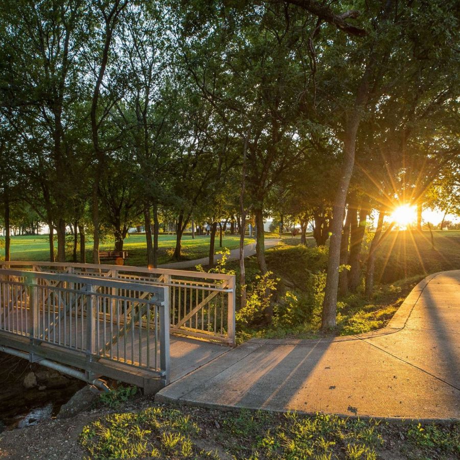 Red Oak, TX with a green park with a bridge and lots of mature trees